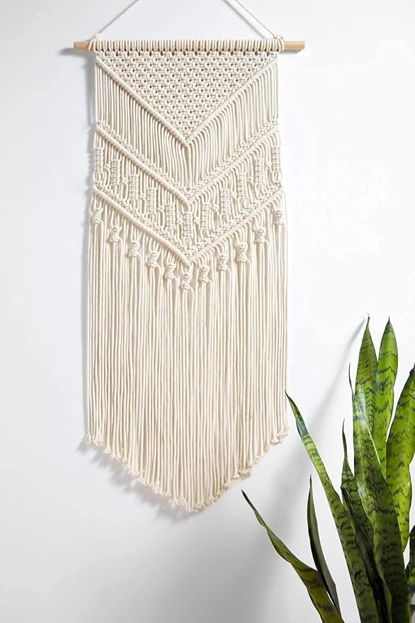 A beautiful macramé wall art hanging above a cozy reading nook